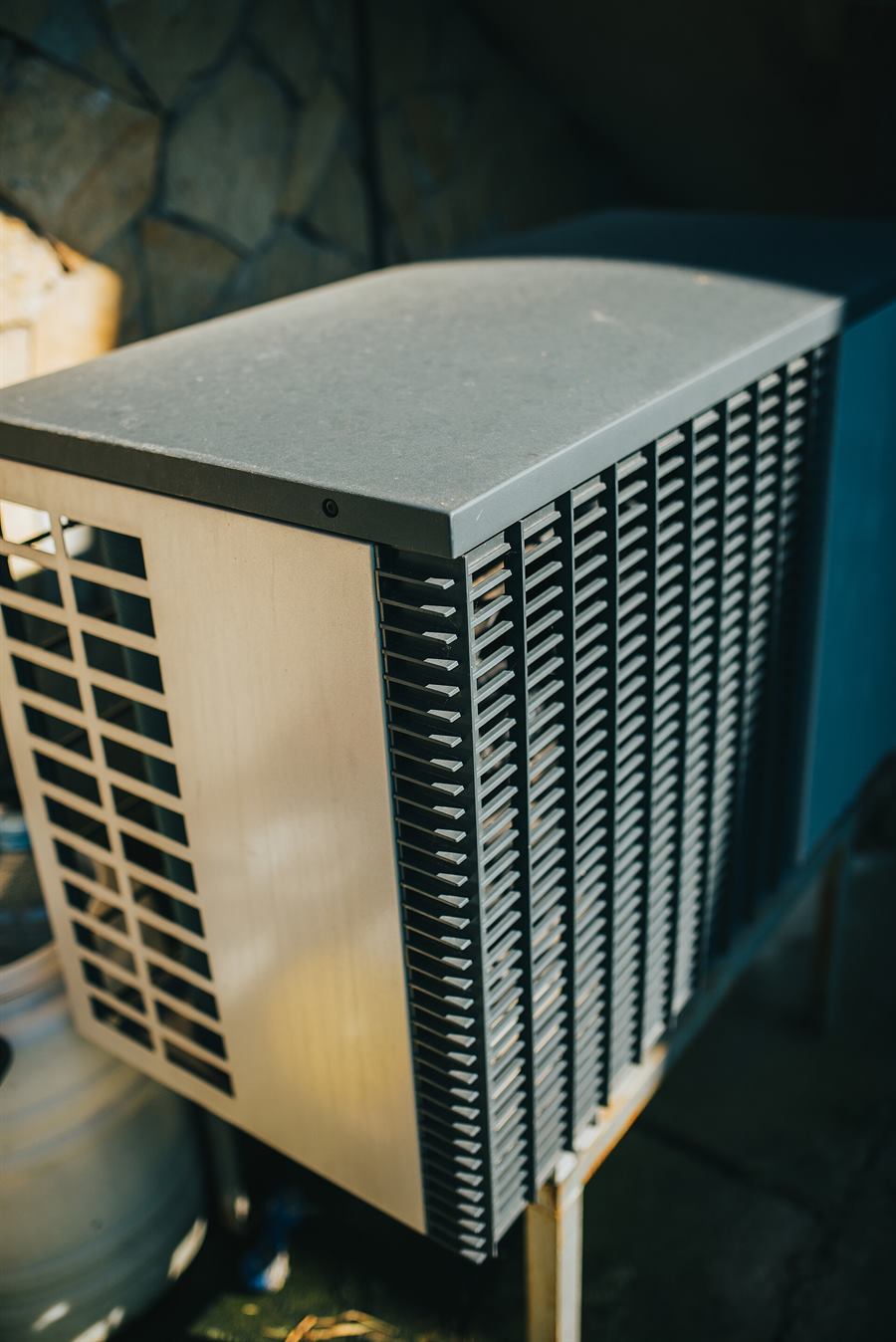 Outdoor air conditioner condenser installed in the garden space of a home